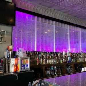 glass water installation behind a bar